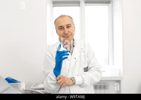 Ritratto di medico mette sul guanto medicale. Foto Stock