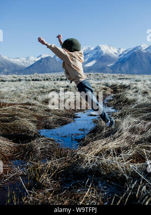 Ragazzo saltando su un flusso di Mammoth Lakes, California, Stati Uniti Foto Stock