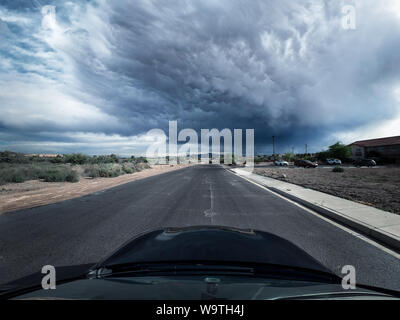 Auto guidando lungo una strada con una tempesta si avvicina, Moapa valley, Nevada, Stati Uniti Foto Stock