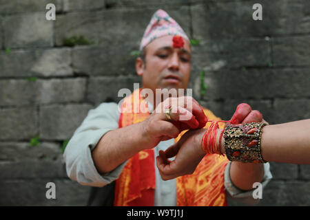 Kathmandu, Nepal. 15 Agosto, 2019. La legatura del battistrada mediante Hidnu sacerdote al tempio di Pashupatinath. Sarita Khadka/Alamy Live News Foto Stock