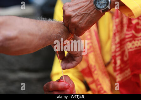 Kathmandu, Nepal. 15 Agosto, 2019. La legatura del battistrada mediante Hidnu sacerdote al tempio di Pashupatinath. Sarita Khadka/Alamy Live News Foto Stock