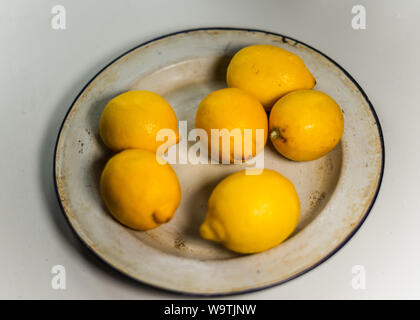 Freschi limoni giallo in smalto vintage piastra. Close up. Foto Stock