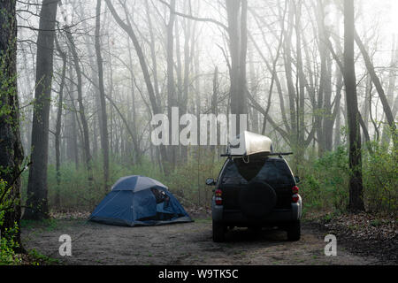 Auto parcheggiate accanto a una tenda nei boschi, Fort Custer State Area ricreativa, Indiana, Stati Uniti Foto Stock