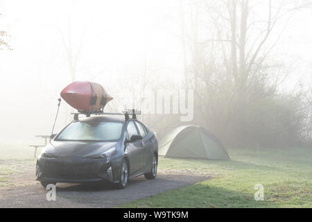 Auto con una canoa parcheggiata da una tenda nei boschi, Fort Custer State Area ricreativa, Indiana, Stati Uniti Foto Stock