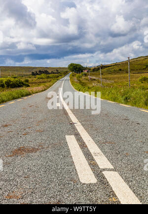 Guardando verso il basso lungo strada asfaltata nelle zone rurali del nord-ovest Irlanda Foto Stock