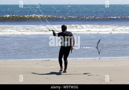 Kite Surfer portante scheda Hydofoil circa per entrare ocean Foto Stock