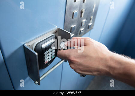 Close-up di mano d'uomo premendo il telecomando in ascensore Foto Stock