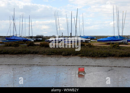 Parzialmente oscurata segno 'Drabbia: morbido fango' a Brancaster Staithe, sulla Costa North Norfolk, con la bassa marea Foto Stock