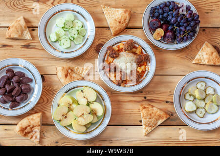 La tabella completa con cibi diversi. Yummy Tavola di Cena con verdure fresche, frutta, pane e dolci. Diversi tipi di alimenti Foto Stock