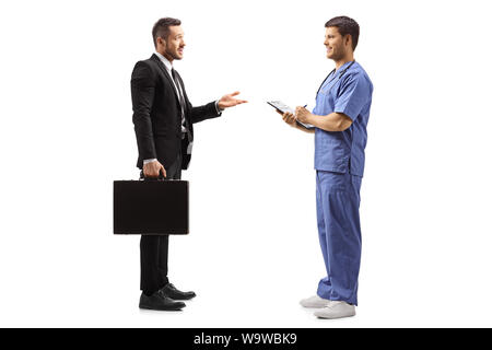 Lunghezza piena ripresa di profilo di un imprenditore con una valigetta gesticolando con la mano e a parlare con un medico di sesso maschile in una uniforme blu isolato su bianco backgr Foto Stock