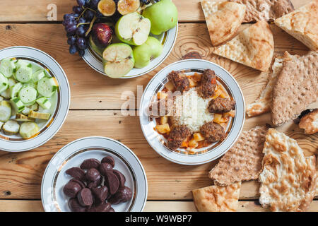 La tabella completa con cibi diversi. Yummy Tavola di Cena con verdure fresche, frutta, pane e dolci. Diversi tipi di alimenti Foto Stock