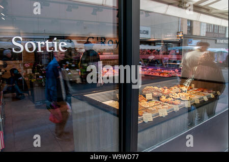Gli acquirenti e i pedoni riflessa nella finestra di charcuterie C'Royal di Dieppe, Francia. Foto Stock