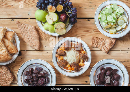 Un tavolo pieno di cibi diversi. Yummy Tavola di Cena con verdure fresche, frutta, pane e dolci. Diversi tipi di alimenti Foto Stock