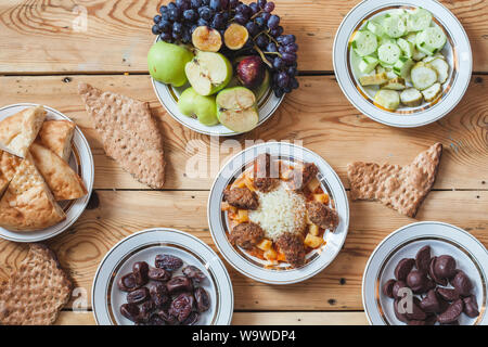 Un tavolo pieno di cibi diversi. Yummy Tavola di Cena con verdure fresche, frutta, pane e dolci. Diversi tipi di alimenti Foto Stock