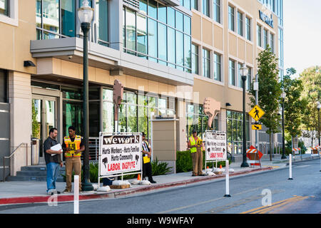 Agosto 14, 2019 San Mateo / CA / STATI UNITI D'AMERICA - persone che protestavano davanti a un ufficio WeWork edificio situato nella Silicon Valley; WeWork è un Americano compan Foto Stock