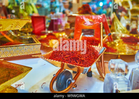 Il piccolo souvenir di rame carriola, caricato con secchi stigmi di zafferano in vetrina del negozio di spezie di Tajrish Bazaar, Teheran, Iran Foto Stock