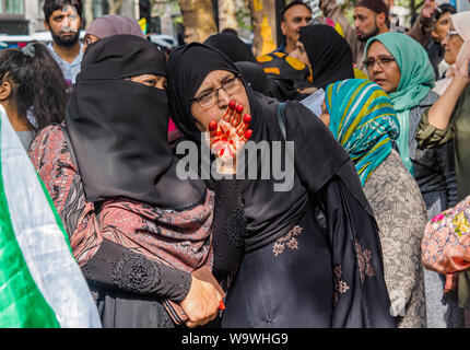 Londra, Regno Unito. Il 15 agosto 2019. Una donna ha una mano con vernice rossa alla protesta al di fuori dell'Alta Commissione Indiana, bloccando Aldwych sulla Indian Giorno di indipendenza contro gli arresti e le violazioni dei diritti umani nella regione del Kashmir. Vari gruppi è venuto per condannare il Primo Ministro Modi la revoca dell'articolo 370 della Costituzione indiana e per chiedere la libertà per il Kashmir che è stata occupata per molti anni da oltre 700.000 truppe indiane. Vogliono che i diritti del popolo del Kashmir e rispettate le risoluzioni delle Nazioni Unite implementata. Peter Marshall / Alamy Live News Foto Stock