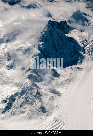 Antenna su Tibet orientale, Cina. Un solitario picco himalayano sale attraverso le nuvole. Foto Stock