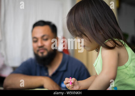 Carino piccolo asiatici a 2 - 3 anni bimbo bambine pittura, kid colorazione con il padre a casa, papà trascorrere del tempo di qualità con il figlio dopo l orario di lavoro Foto Stock