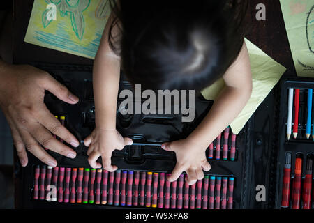 Carino piccolo asiatici a 2 - 3 anni bimbo bambine pittura, kid colorazione con il padre a casa, papà trascorrere del tempo di qualità con il figlio dopo l orario di lavoro Foto Stock