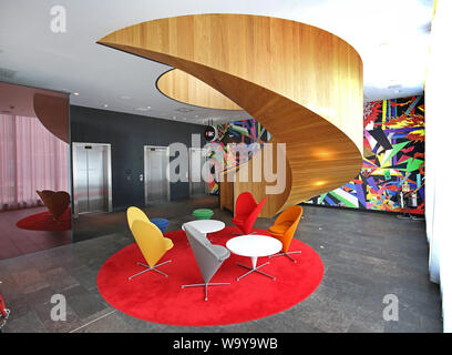Circolare, scala in legno al piano terra ingresso al cittadino M hotel in Shoreditch, Londra. Foto Stock