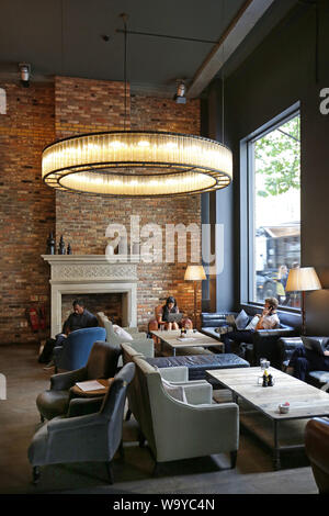 I clienti a rilassarsi nella hall, area bar e ristorante a Londra alla moda Hoxton Hotel in Shoreditch, REGNO UNITO Foto Stock