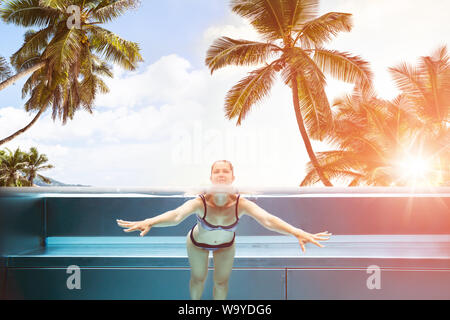 Sopra sotto acqua foto di donna di nuoto in piscina nel resort tropicale Foto Stock