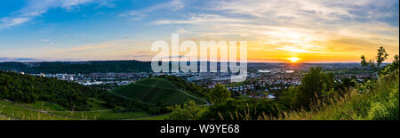 Germania, XXL panorama di romantico arancione tramonto Cielo sopra le case di bella metropoli città Stoccarda in valle tra vigneti dal di sopra Foto Stock