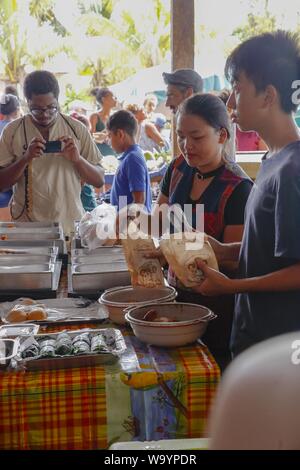 CACAO, Francia - Lug 25, 2019: giovane donna Hmong e l uomo la vendita di cibo di strada in una fase di stallo. Mercato di domenica, cacao, Guiana francese, Francia Foto Stock