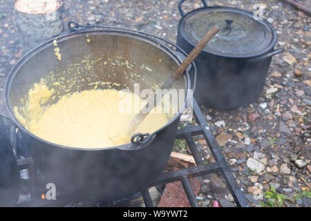 Porridge di mais viene cotta in una pentola al rogo. campeggio cucina cucina in viaggio Foto Stock