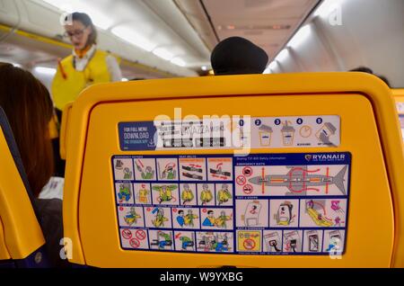 Interno di un volo Ryanair con equipaggio di cabina dando dimostrazione di sicurezza Foto Stock