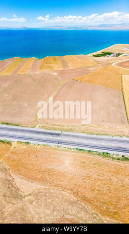 Vista aerea del lago di Van il lago più grande in Turchia, campi e scogliere che si affaccia sulle acque cristalline. Strade lungo il lago Foto Stock