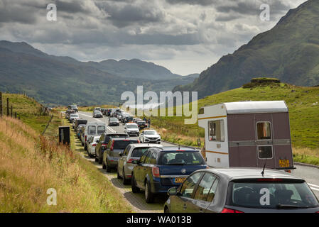 Congestione a Snowdonia, Galles del Nord, 15 agosto 2019. Auto parcheggiate legalmente sulla A498 - il passo Nant Gwynant, comodo per gli escursionisti per accedere alla pista PYG e Miners Track, che conduce alla vetta di Snowdon. La popolarità del parco nazionale in estate significa che molti turisti guidano alla zona, ci è traffico molto e questi parcheggi sono spesso pieni. Il passo scende a Llyn Gwynant e ad un altro parcheggio popolare tra le persone che salgono su Snowdon attraverso il sentiero Watkins. Questa strada conduce anche al bellissimo villaggio di Beddgelert e alla pittoresca Llyn Dinas. Foto Stock