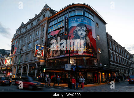 London, Londra, Regno Unito. 12 Ago, 2019. Le persone passano dalla regina del teatro nel West End di Londra, Gran Bretagna il 12 agosto, 2019. Affascinanti vedute di notte e varie attività serali e comodo trasporto a Londra offrono alla gente una vibrante vita notturna. Credito: Han Yan/Xinhua/Alamy Live News Foto Stock