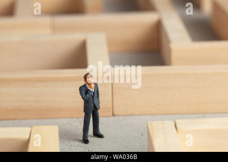 Imprenditore nel labirinto come simbolo di risolvere i problemi e trovare una buona via di uscita Foto Stock
