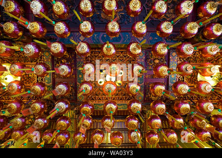 Guardando dritto fino ad una bella lanterna pensile array in un tempio Cinese a Kuching, Malaysia. Foto Stock