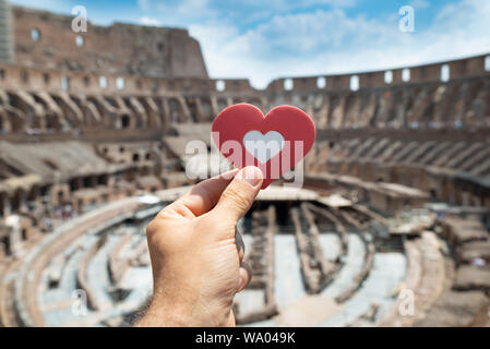 Uomo con forma di cuore all'interno del Colosseo, Italia Foto Stock