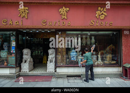 Hong Kong Cina. 16 Ago, 2019. Un uomo è la pulizia le finestre di un negozio di antiquariato. In Hong Kong vi sono state massicce proteste per più di due mesi. Le dimostrazioni sono state innescate da un disegno di legge del governo - ora in attesa - per l'estradizione di sospetti criminali in Cina. Credito: Gregor Fischer/dpa/Alamy Live News Foto Stock