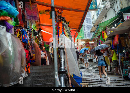 Hong Kong Cina. 16 Ago, 2019. Proprietario del negozio osserva i clienti passando il suo negozio su un mercato. In Hong Kong vi sono state massicce proteste per più di due mesi. Le dimostrazioni sono state innescate da un disegno di legge del governo - ora in attesa - per l'estradizione di sospetti criminali in Cina. Credito: Gregor Fischer/dpa/Alamy Live News Foto Stock