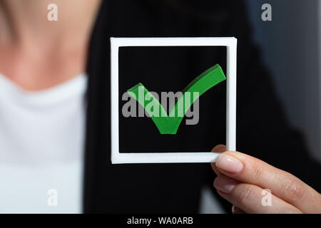 Close-up di un imprenditore di mano azienda Icona segno di spunta verde Foto Stock