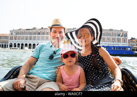 La famiglia felice in vacanza in barca a vela nella gondola di Venezia Foto Stock