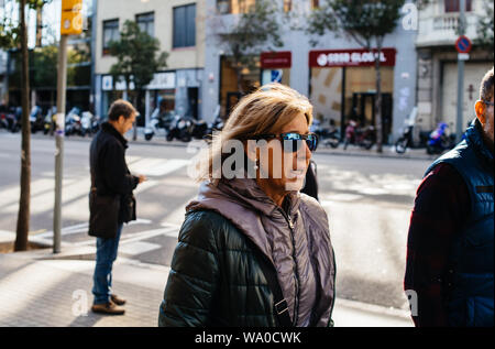 Barcellona, Spagna - 14 Nov 2017: vista laterale della femmina adulta tourist indossando occhiali da sole nel centro di Barcellona a scoprire la città Foto Stock