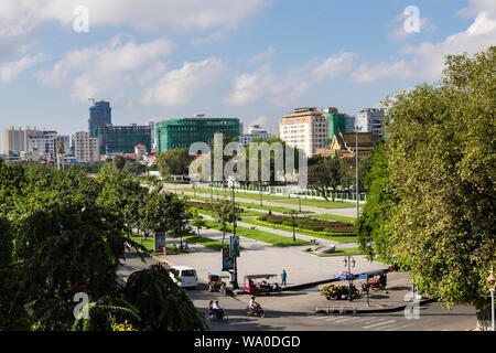 Scena di strada con giardini pubblici ed edifici in costruzione nella città capitale. Phnom Penh, Cambogia, sud-est asiatico Foto Stock