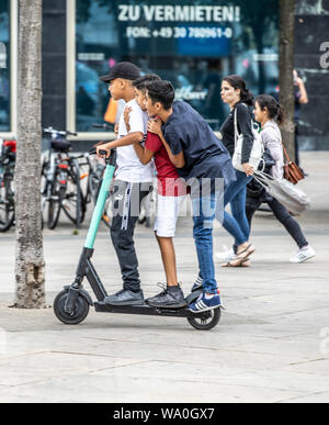 E-scooter, scooter elettrico, noleggio scooter, guida, ad Alexander Platz a Berlino per 3 persone su uno scooter, Foto Stock