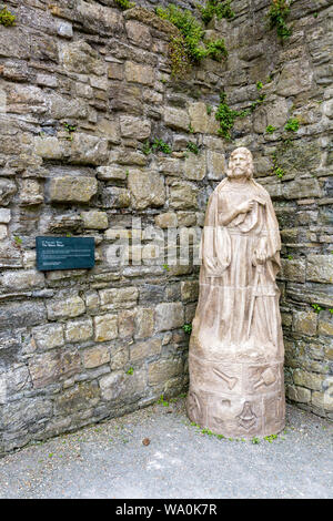 Una statua di uno dei maestri muratori responsabile per la costruzione di Beaumaris Castle, Anglesey, Galles, Regno Unito Foto Stock