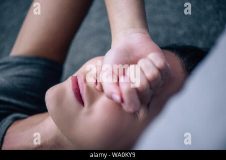 Messa a fuoco selettiva di sconvolgere lonely donna che copre gli occhi a casa Foto Stock