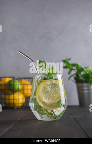 Infuso di acqua con limone e zenzero e menta in vetro. Close up. Una sana detox bevanda per la mattina. Foto Stock