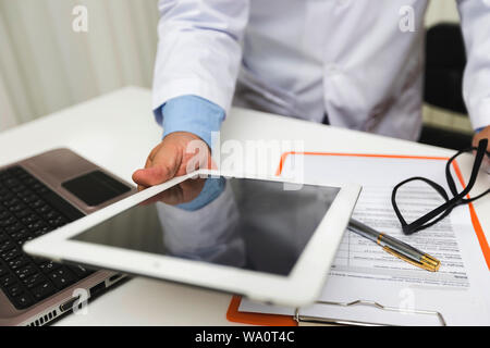 Medico che lavorano con il tablet PC alla scrivania. Tecnologia e concetto medico. Foto Stock