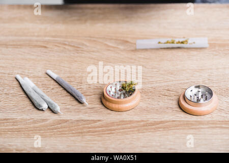 Giunti con la marijuana medica e herb grinder sul tavolo Foto Stock