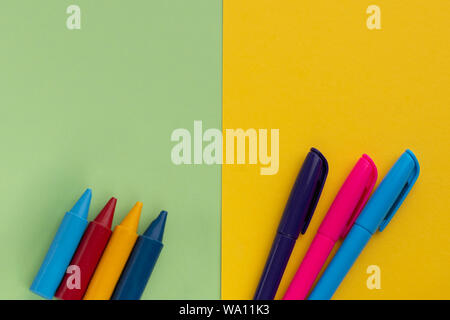 Si torna a scuola, minimalismo concetto. Forniture scolastiche. Pennelli per verniciatura, penne, matite, gomma, pennarelli sul trendy blu verde giallo carta a colori Foto Stock